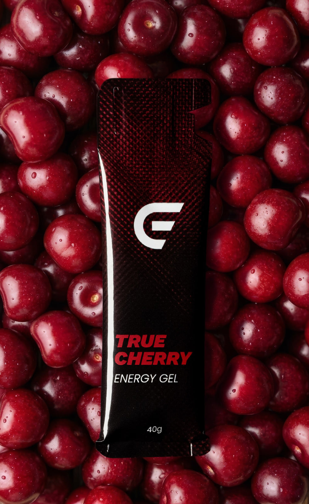 ONE ENERGY True Cherry Energy Gel vor einem Hintergrund aus frischen Sauerkirschen